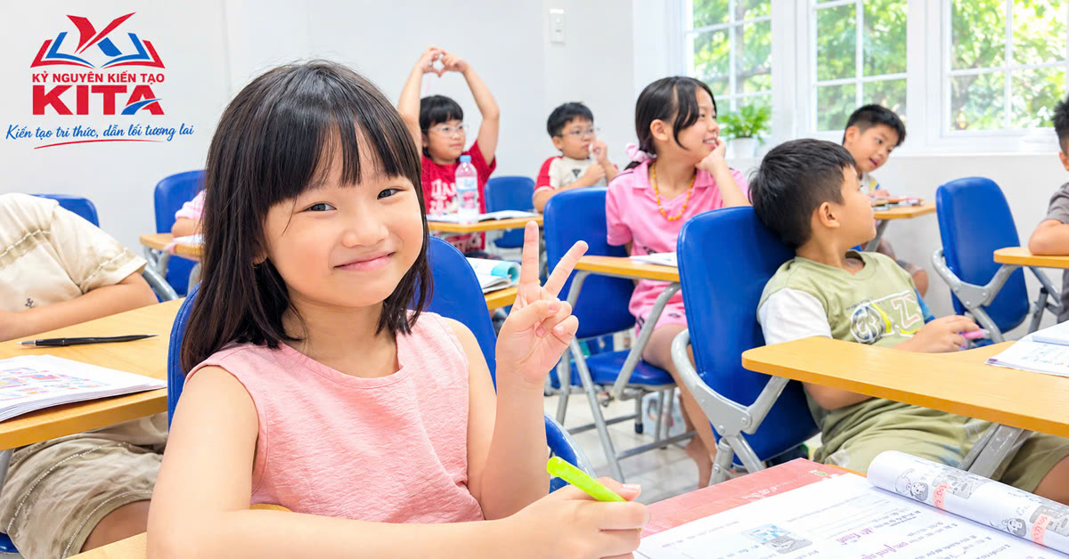Bé gái giơ tay chữ V trong lớp học tiếng Anh tại KITA